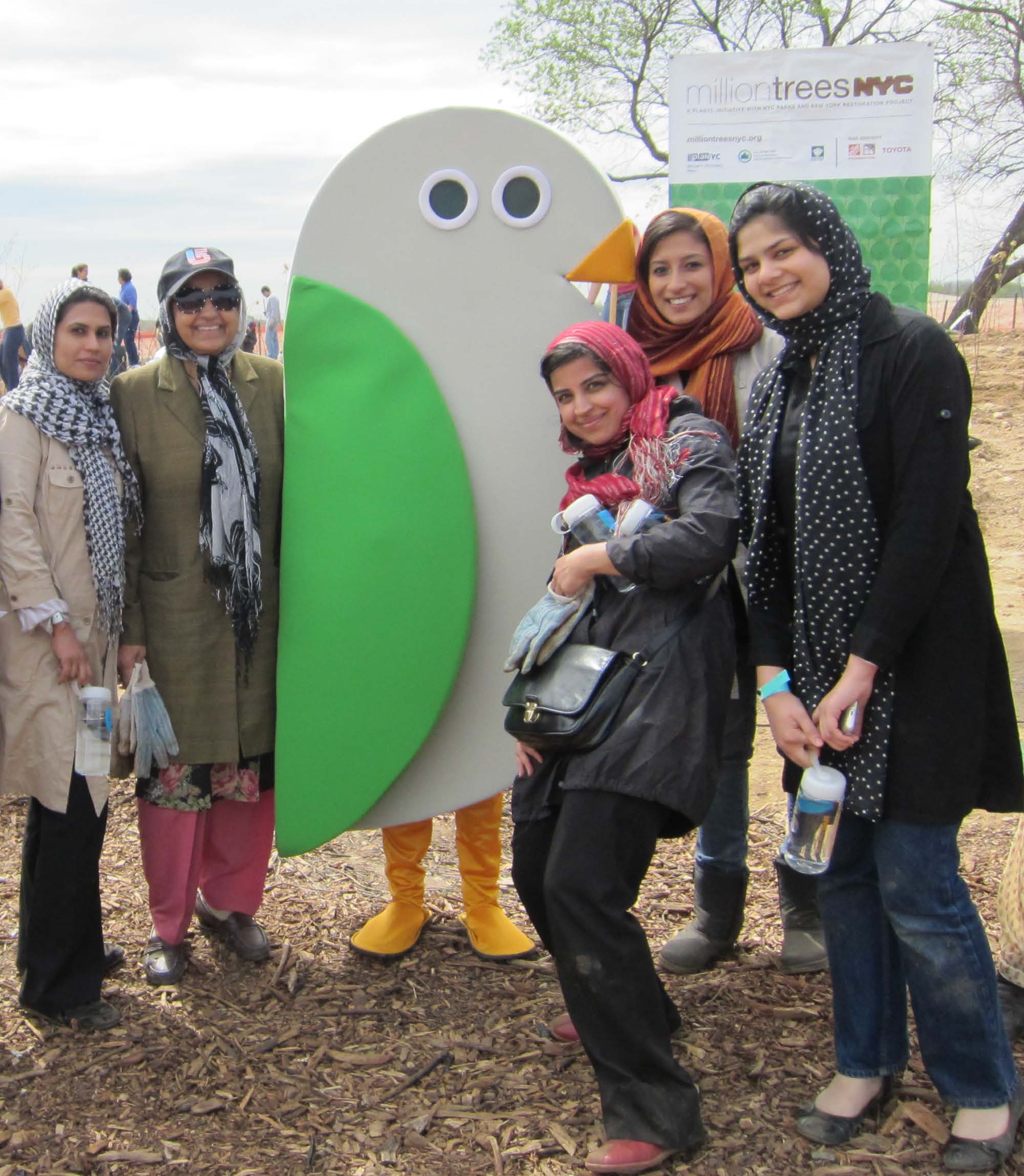 People posing with the GreeNYC mascot, Birdie